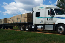 Flatbed truck transporting pre-loaded with building materials.