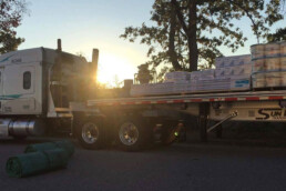 Sunbelt Transport flatbed truck loaded with construction materials, ready for delivery.